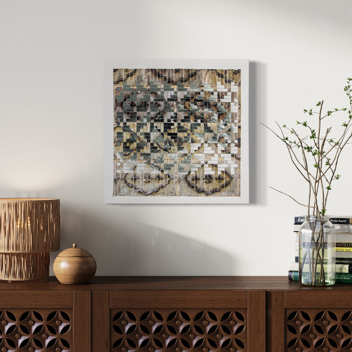 The artwork 'Blending In' by Kiana Honarmand features a pixelated mosaic pattern in muted earth tones, created from hand-cut and woven giclee prints. Abstract geometric squares and rectangles blend together in shades of beige, gray, and brown, creating a digitally-inspired textural composition. The 18x18 inch piece explores themes of camouflage and digital fragmentation. Art by Kiana Honarmand.