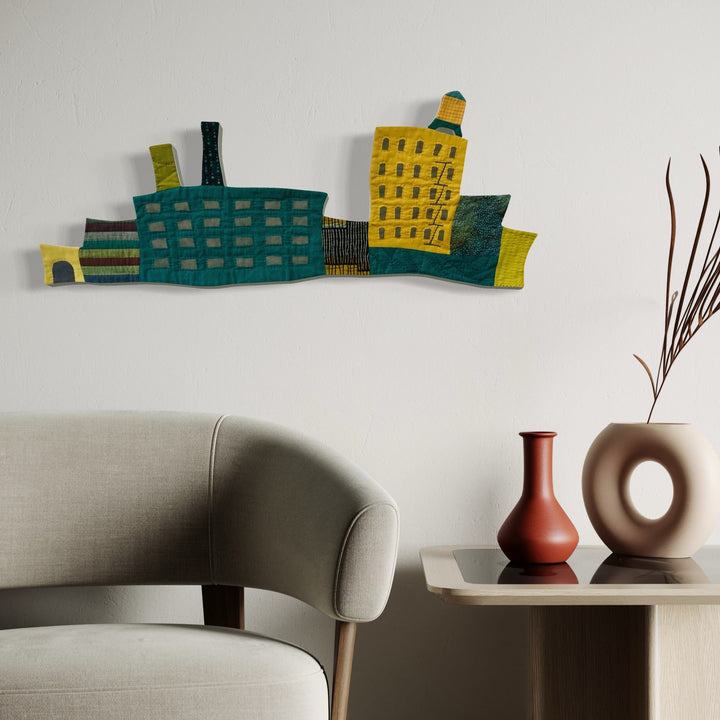 A photo of the artwork Cityscape (Shades of Teal & Mustard), by Ann Cofta, hanging on a wall.