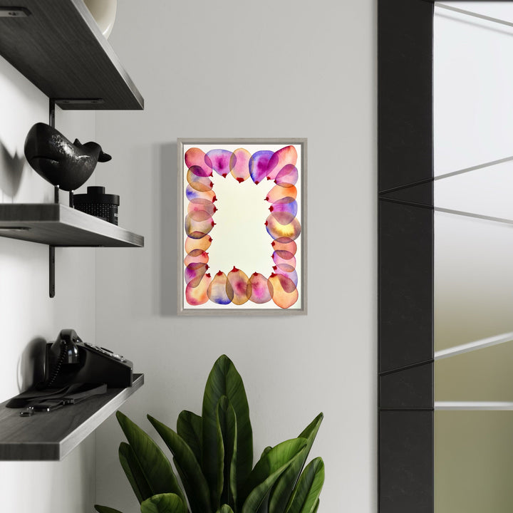 The artwork 'Coalition 3' by Monica Carrier features a vibrant abstract watercolor border in pink, purple, and orange hues surrounding a cream-colored center. The fluid, organic shapes create a harmonious frame effect, painted with archival ink on paper, measuring 14x10 inches, displayed in a modern silver frame against a light wall.