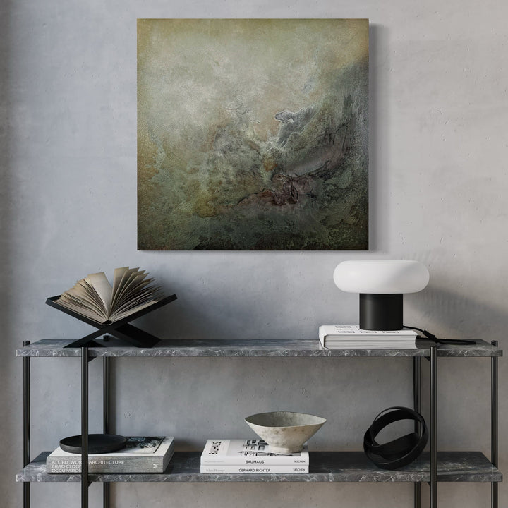 The artwork 'Departing Dream' by Abbey Stace features abstract textural layers in muted sage, charcoal, and bronze tones. The mixed-media composition combines plaster, acrylic, oil, and sand, creating a misty, dreamlike atmosphere with organic movement and ethereal depth. The 24x24 inch piece evokes a moody, atmospheric landscape. By Abbey Stace.