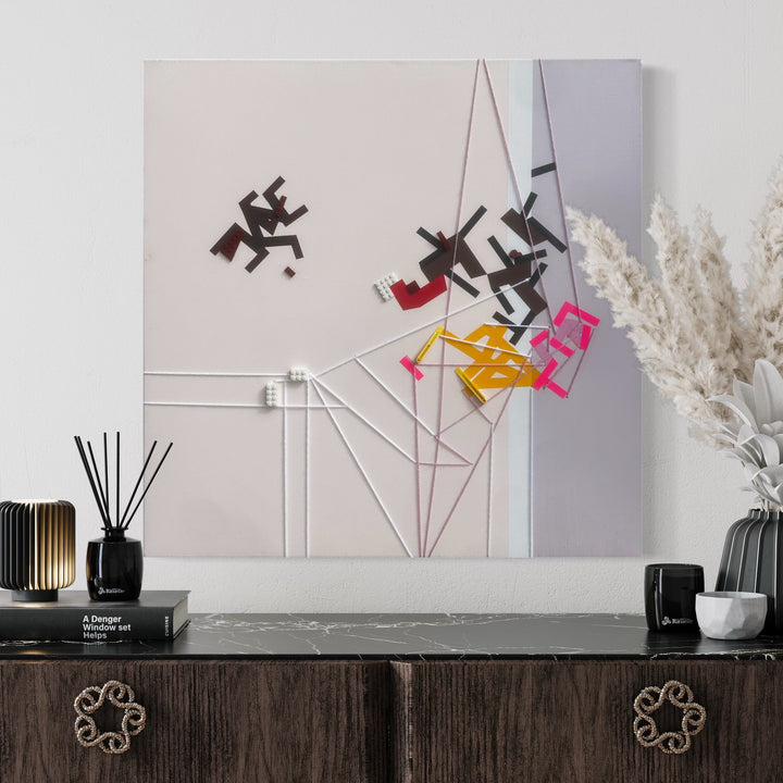 The artwork 'Elever Aurrakinesiss' by Philippe Halaburda features abstract geometric shapes in black, red, yellow, and pink, arranged dynamically across a white canvas. Linear white elements create architectural intersections, while scattered letter-like forms appear to float and dance across the composition. The 30x30 inch mixed media piece combines minimalist design with bold color accents.