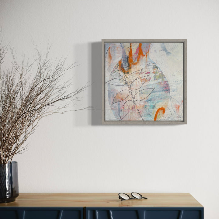 The artwork 'Evanescence' by Giliane Bader features delicate organic line work against a soft white background, with splashes of vibrant orange and subtle blue tones. Abstract leaf-like forms emerge through layers of mixed media, creating an ethereal composition on birch panel. The cold wax finish adds depth and translucency to the 12x12 inch piece.