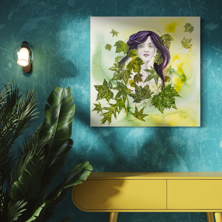 The artwork 'Flora' by Sandra Mack-Valencia features a whimsical portrait set against a luminous yellow-green background. Delicate green maple leaves float and swirl around a central ethereal figure with flowing purple hair. Created with acrylic and ink on wood panel, the 30x30 inch piece combines botanical elements with dreamy watercolor effects and transfer techniques.