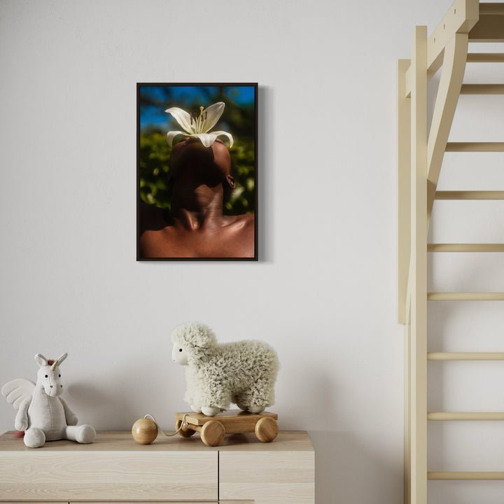 The artwork 'Flower Study IV' by Eunice Pais captures a delicate white lily blossom positioned against a natural backdrop of soft-focused blue sky and green foliage. The contemporary photographic composition features a minimalist aesthetic with dramatic contrast between the luminous flower petals and dark background. The 27x18 inch fine art photograph showcases artistic portraiture and natural elements. By Eunice Pais.