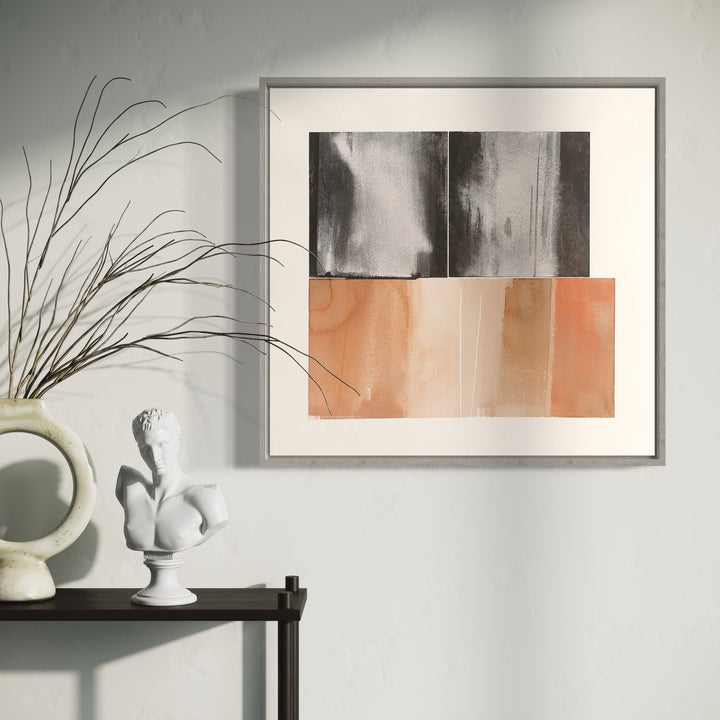 The artwork 'Ghost Rider I' by Ken Schiano features a minimalist abstract composition divided horizontally, with moody black and gray watercolor washes in the upper portion contrasting against soft coral and peach tones below. The piece showcases fluid brush strokes and subtle color transitions, framed in a modern silver frame, measuring 21 x 22 inches. By Ken Schiano.