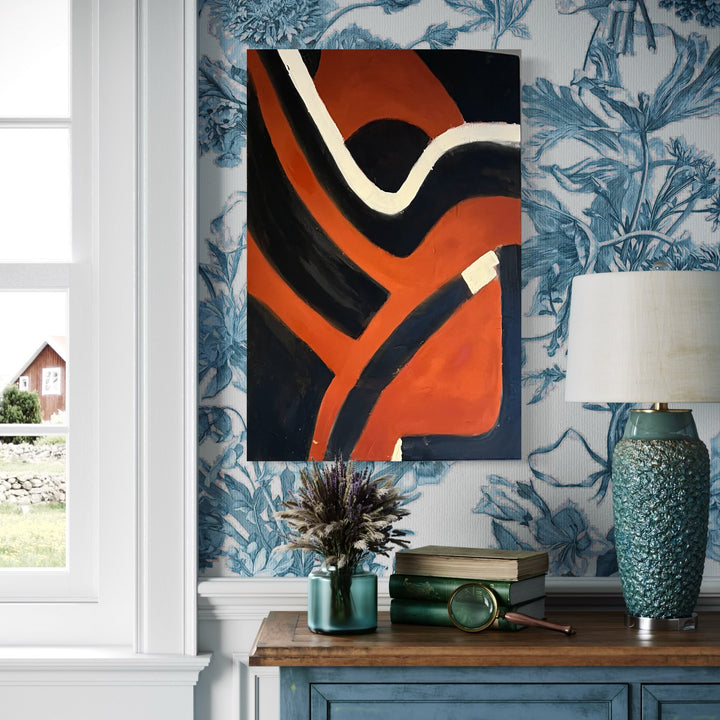 The artwork 'Grounding' by Genevieve Antonello features bold abstract curves in striking orange and black, with contrasting white lines creating dynamic movement across the canvas. The composition showcases fluid, modern shapes against a dark background, combining minimalist design with powerful geometric elements in oil paint on a 30x20 inch canvas.