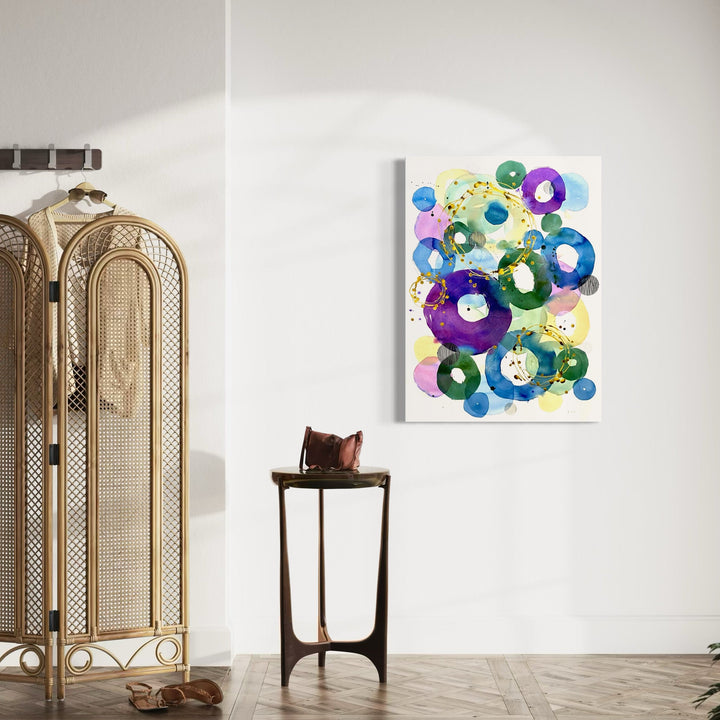 The artwork 'In Harmony' by Jocelyn Benford features vibrant circular forms in watercolor, creating a dynamic composition of overlapping rings in deep purple, bright blue, and fresh green tones. Splashes of yellow dots add sparkle throughout the abstract piece, while transparent layers create depth and movement. The mixed media elements enhance the flowing, organic nature of the 42x31 inch artwork.