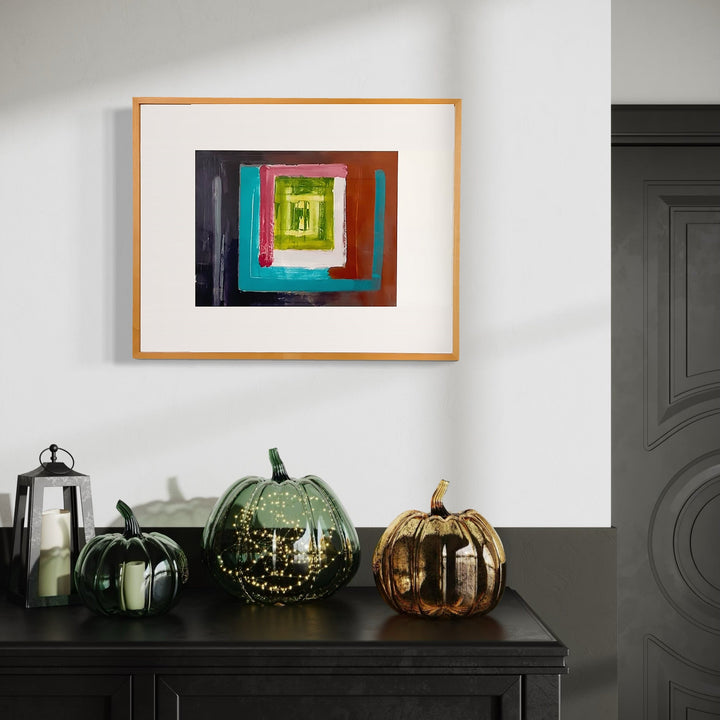 The artwork 'Inside Out 104' by Don Wass features concentric squares in vibrant colors including turquoise, red, brown, and lime green, creating a tunnel-like effect. The abstract composition on paper uses bold acrylic strokes, framed in a natural wood frame. The geometric shapes appear to spiral inward, creating depth and dimension through color layering.