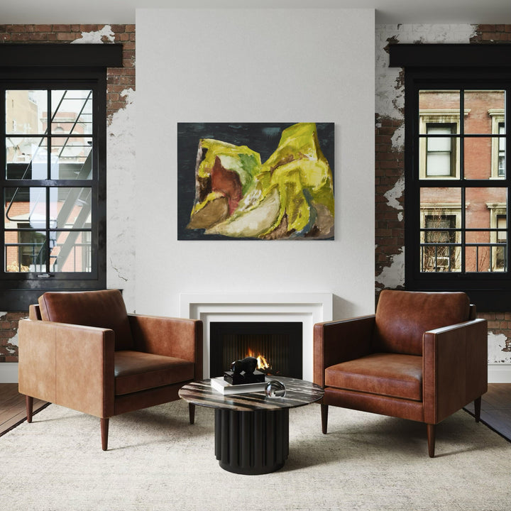 Landmannalaugar 1 by Marianne Barcellona features abstract organic forms in vibrant yellow and olive tones against a dark background, displayed above a modern fireplace between two leather armchairs. The oil painting's dynamic brushstrokes create fluid, nature-inspired shapes that evoke the Icelandic landscapes, measuring 36x48 inches on canvas.