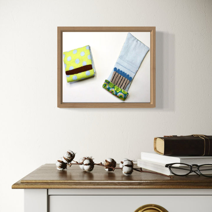 A photo of the artwork Matchbooks (Blue & Green), by Ann Cofta, hanging on a wall.