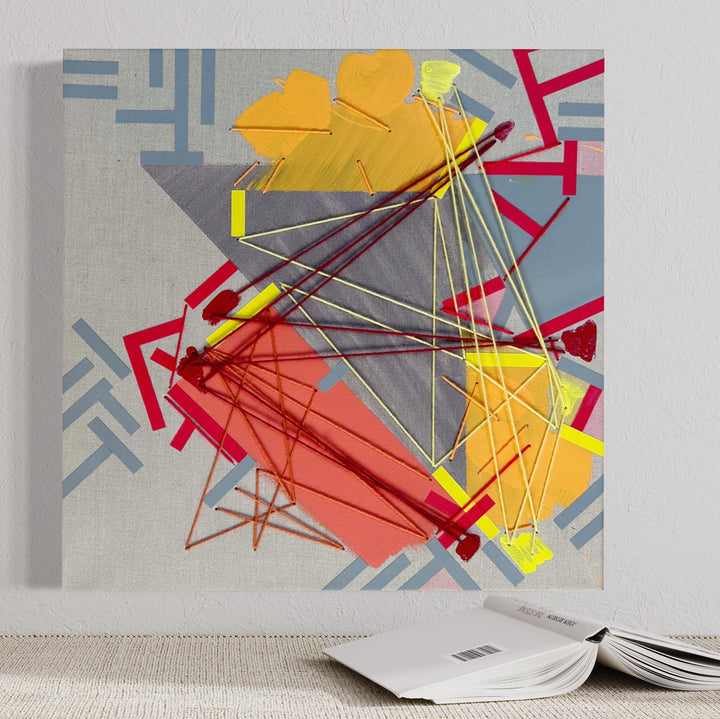 The artwork 'Needeen' by Philippe Halaburda features a dynamic abstract composition with geometric shapes in yellow, coral, and gray. Intersecting lines created with yarn form a web-like pattern across the canvas, while angular shapes and chevron patterns in blue accent the corners. Mixed media techniques combine acrylic paint, tape, and yarn on a 20x20 inch canvas.