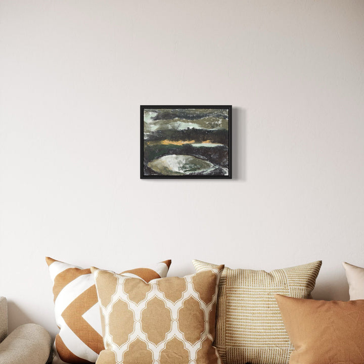 The artwork 'Night Depression' by Todd Gilens features a moody abstract landscape rendered in dry pigment on paper. Dark storm clouds dominate the upper portion, with hints of silvery moonlight breaking through. A circular form below suggests a reflective pool or crater, executed in muted grays and whites, creating a haunting nocturnal atmosphere. Framed in black, measuring 11x14 inches. By Todd Gilens.