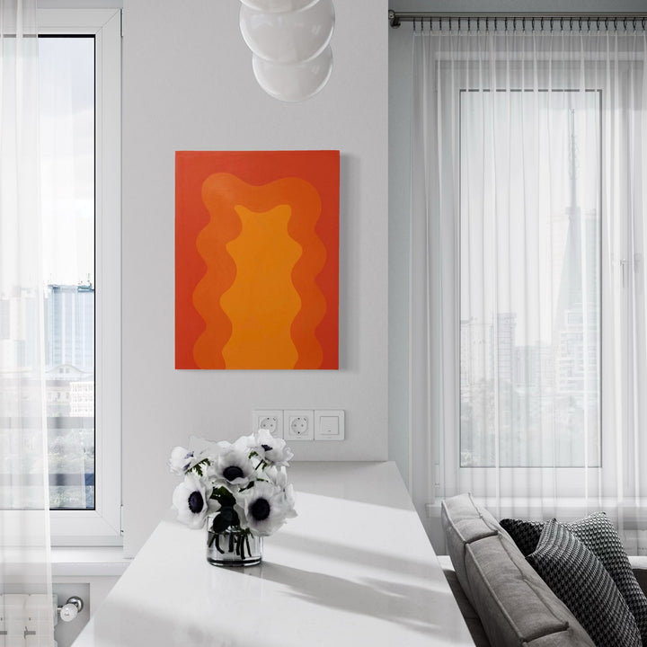 The artwork 'Orange' by Shadia Sabagh features vibrant waves of orange and coral hues flowing vertically across an acrylic canvas. Abstract undulating forms create a dynamic composition reminiscent of flames or liquid movement. Contemporary minimalist style artwork displayed in a modern interior setting, measuring 24x18 inches from the Energy of Color Series.