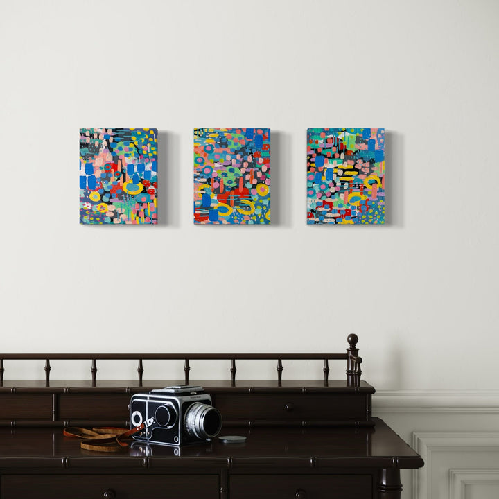 A photo of the artwork Pixelated Floral Triptych, by Alexandra Jamieson, hanging on a wall.