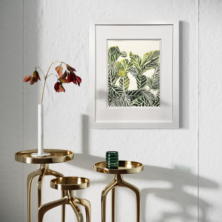 The artwork 'Plant Life II' by Rachel Kohn features a vibrant watercolor and ink composition of overlapping tropical leaves in varying shades of green, creating a lush botanical pattern within a white frame. The delicate brushwork captures the organic textures and natural flow of foliage, displayed in a modern minimalist style.