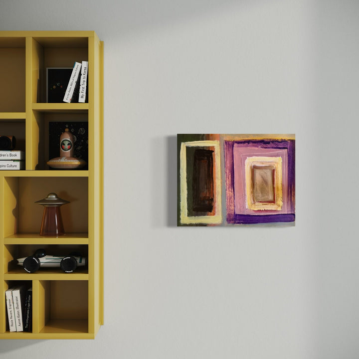 The artwork 'Portal' by Don Wass features abstract geometric shapes in concentric rectangles, painted in rich contrasting colors of deep brown, vibrant purple, and pale yellow. The acrylic on paper piece creates a dimensional portal effect through layered frames, mounted on a gray wall beside a yellow shelving unit.