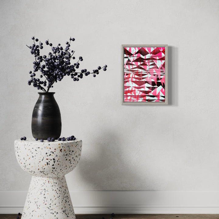 The artwork 'Rain Date' by Ann Tarantino features dynamic geometric patterns in vibrant pink and white, with bold black linear elements creating an abstract layered composition. The acrylic on laser-etched panel artwork measures 12x9 inches, showcasing a modern, energetic design with intersecting shapes and striking contrasts. Created by Ann Tarantino.