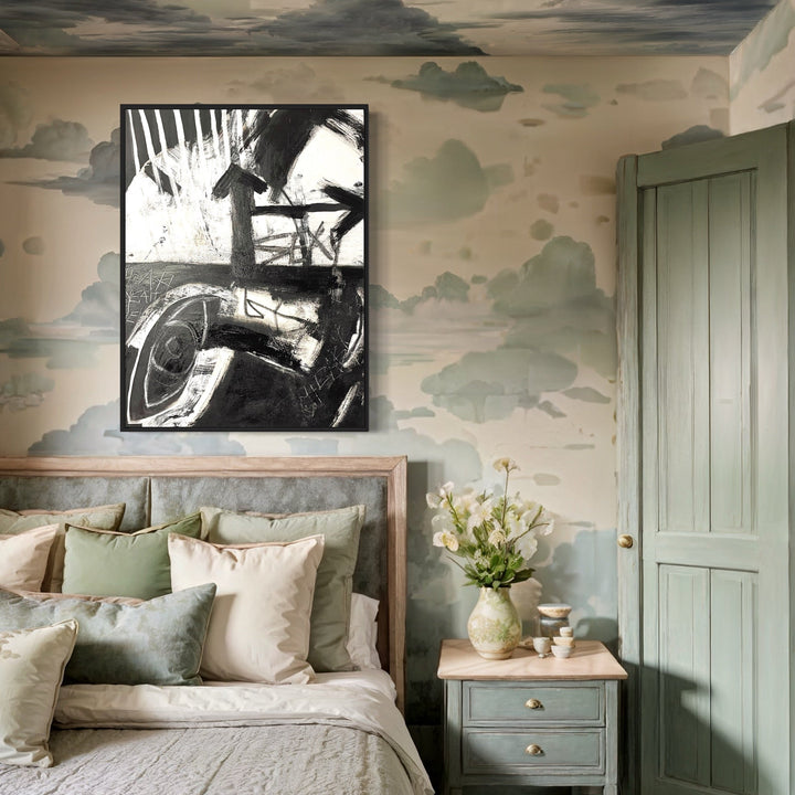 The artwork 'Sexy' by Jodi Fuchs features a striking black and white vintage automotive photograph displayed in a bedroom with sage green walls decorated with cloud motifs. The monochromatic print shows abstract mechanical details, creating a bold contrast against the soft, pastoral wall treatment and neutral bedding. Created with acrylic and oil stick on canvas, 40x30 inches.