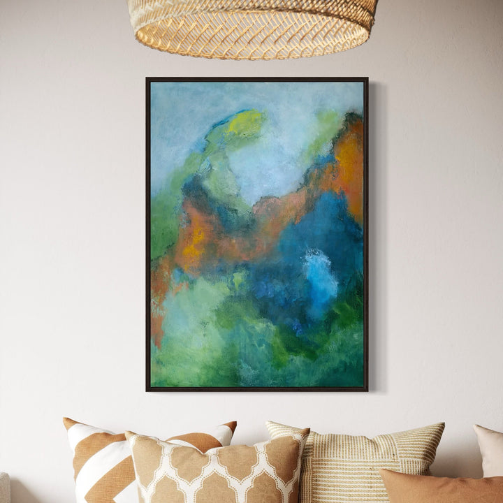 The artwork 'Soft Murmur' by Janyce Erlich-Moss features an abstract composition of swirling blues, greens, and warm orange tones. The acrylic painting on canvas creates a dreamlike atmosphere with fluid brushstrokes that blend seamlessly, suggesting underwater currents or celestial clouds. Deep azure blues transition into misty seafoam greens, with touches of rust-orange adding warmth and depth to the 36.5 x 24.5 inch piece.