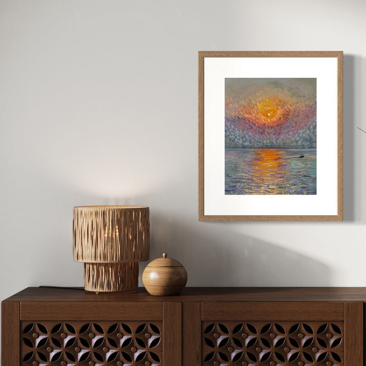 The artwork 'Sunset in Bombay' by Claudia Robles-Gil captures a vibrant orange sun setting over calm waters, rendered in expressive brushstrokes. The sky features a textured blend of coral, purple, and gold hues, while the water reflects the sun's glow in rippling patterns. Oil on canvas, framed in natural wood, 14x11 inches. By Claudia Robles-Gil.