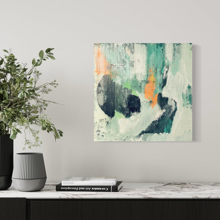 The artwork 'The World Keeps Turning' by Tammy Kushnir features dynamic abstract brushstrokes in a harmonious blend of teal, mint green, navy blue, and soft peach tones. The 24x24 inch mixed media painting displays expressive gestural marks and textured layers, creating a sense of movement and depth against a light background, by Tammy Kushnir.