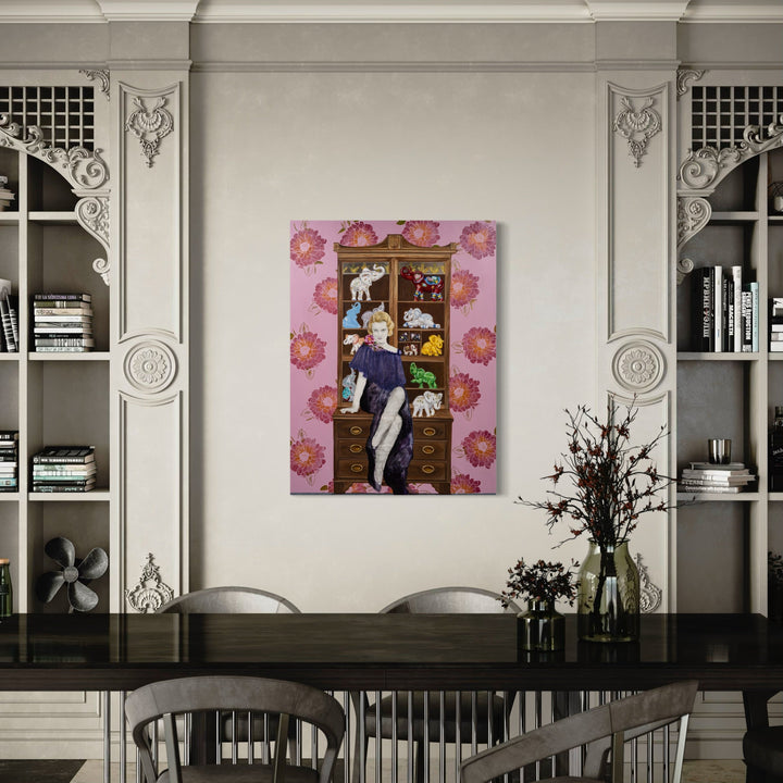 The artwork 'Thirteen Elephants and a Blonde' by Sandra Mack-Valencia features a whimsical composition on a pink background decorated with floral motifs. A figure sits atop a wooden cabinet displaying colorful miniature elephant figurines. The acrylic painting on wood panel combines transfer techniques, creating a playful narrative within an elegant 48x36 inch format.