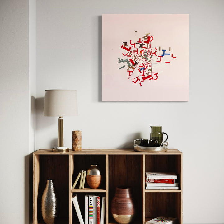 The artwork 'liiruonnil' by Philippe Halaburda features an abstract composition of dynamic red, blue, and gray angular shapes arranged in a scattered cluster formation against a clean white canvas. The geometric elements resemble dancing figures or interconnected pathways, creating a sense of movement and energy in this mixed media piece, measuring 36 x 36 inches.