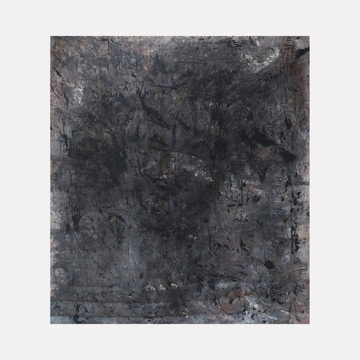 The artwork 'Bastone' by Jacqueline Ferrante features a richly textured abstract composition in deep charcoal and slate grays, with subtle iridescent highlights. The surface exhibits a weathered, dimensional quality created through layered plaster and acrylic, with organic scratches and marks suggesting geological formations or urban decay. 45x53 inches. By Jacqueline Ferrante.