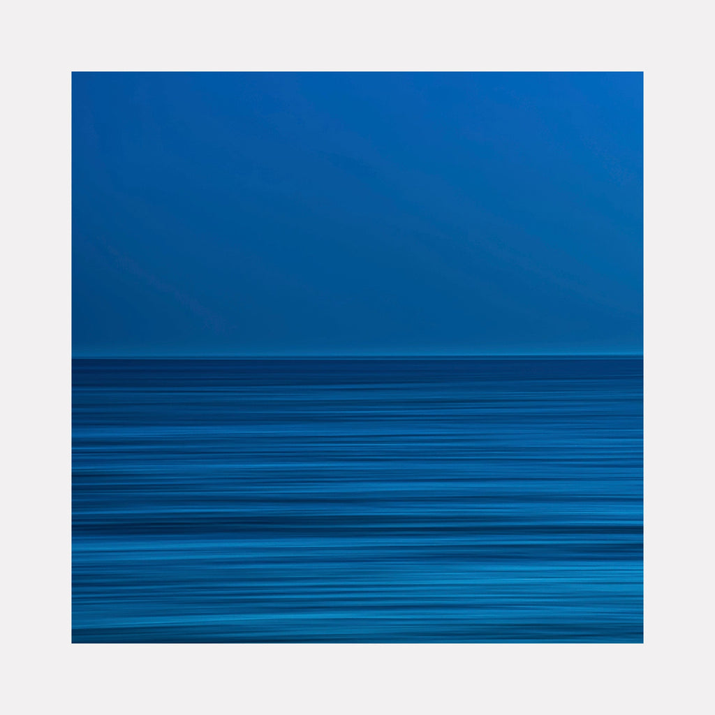 The artwork 'Blue Pacific' by Neil Shapiro features a minimalist seascape composition with horizontal striations in varying shades of deep and electric blue. The upper portion shows a solid cerulean sky meeting a textured ocean surface, created through parallel linear patterns that suggest rippling water, printed on premium Hahnemühle paper.