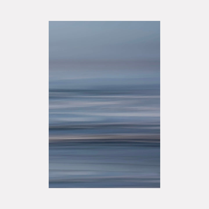 The artwork 'Bluff Cove' by Neil Shapiro features an abstract seascape with horizontal brushstrokes in muted blues and grays. The composition creates a dreamy, motion-blurred effect suggesting ocean waves and misty atmosphere, printed on textured Hahnemuhle paper. The minimalist design captures the ethereal quality of coastal weather.