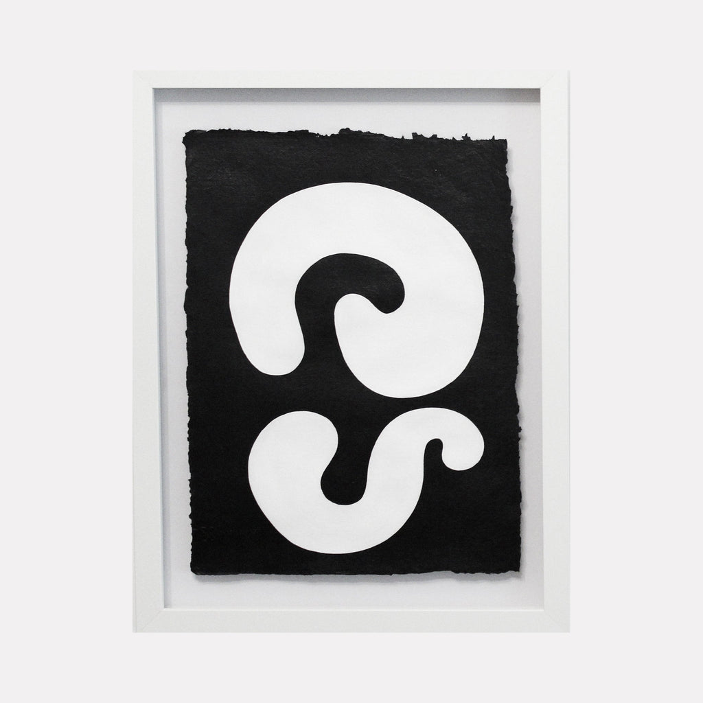 The artwork 'Duality III' by Shadia Sabagh features bold abstract white spiral forms against a deep black background on handmade cotton paper. The minimalist composition showcases two curved shapes creating a striking contrast and sense of movement. Framed in white, this acrylic painting exemplifies modern geometric abstraction with organic flowing lines.