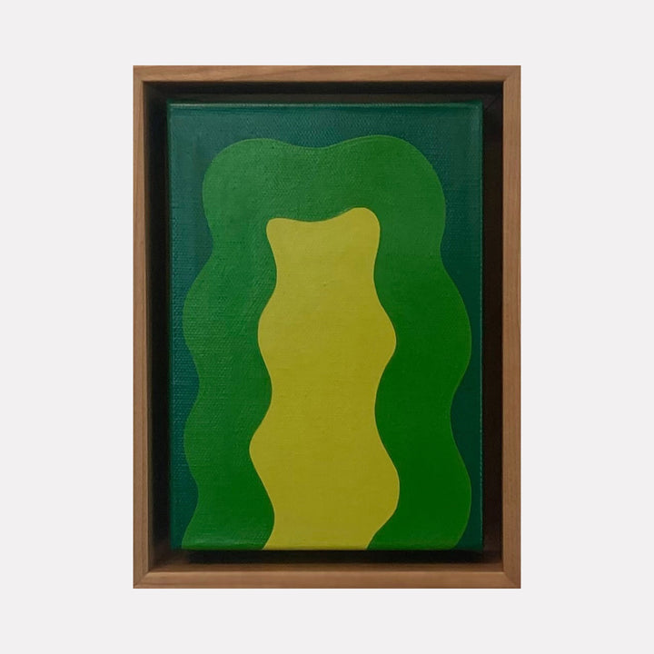 The artwork 'Green Mini' by Shadia Sabagh features abstract organic shapes in vibrant emerald and lime green tones. A central wavy yellow form is framed by undulating deep green curves, creating a dynamic composition on canvas. The piece is presented in a brown wooden frame against a dark green background.