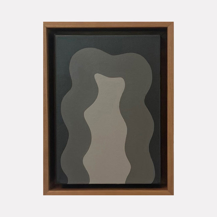 The artwork 'Grey Mini' by Shadia Sabagh features abstract wavy forms in varying shades of grey, creating a fluid, organic composition. The minimalist painting showcases three vertical undulating shapes against a dark background, framed in brown wood, expressing movement and rhythm through simple geometric forms. Acrylic on canvas, 8x6 inches.