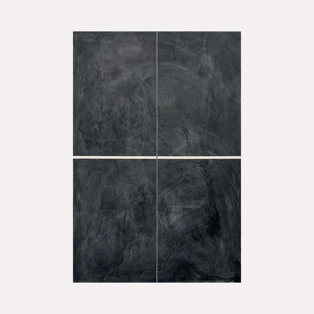 The artwork 'Erasure 42' by Erika Mahr features a minimalist composition divided into four equal panels, showcasing deep charcoal and graphite textures on dura-lar. Abstract gestural marks and shadowy depths create a moody, weathered surface reminiscent of slate or aged metal, with subtle variations in darkness and light across each quadrant.