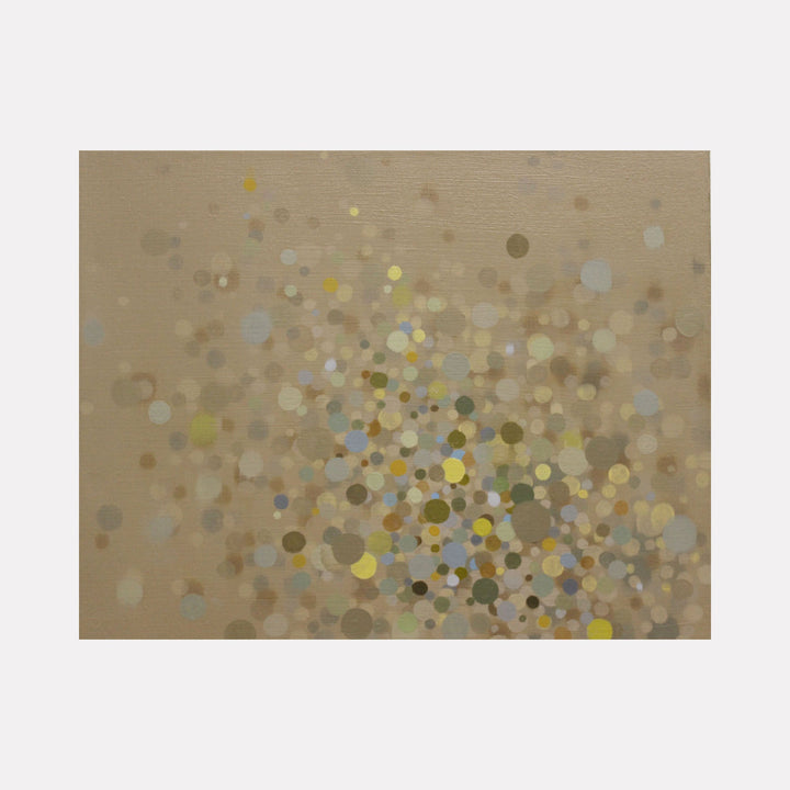 The artwork 'Origin' features a mesmerizing array of scattered circular dots in muted tans, soft blues, and golden yellows on a neutral beige background. The oil painting creates an abstract composition reminiscent of bokeh effects, with varying sizes of dots dispersed across the canvas creating depth and movement. 42x96 inches. By Lisa Ingram.