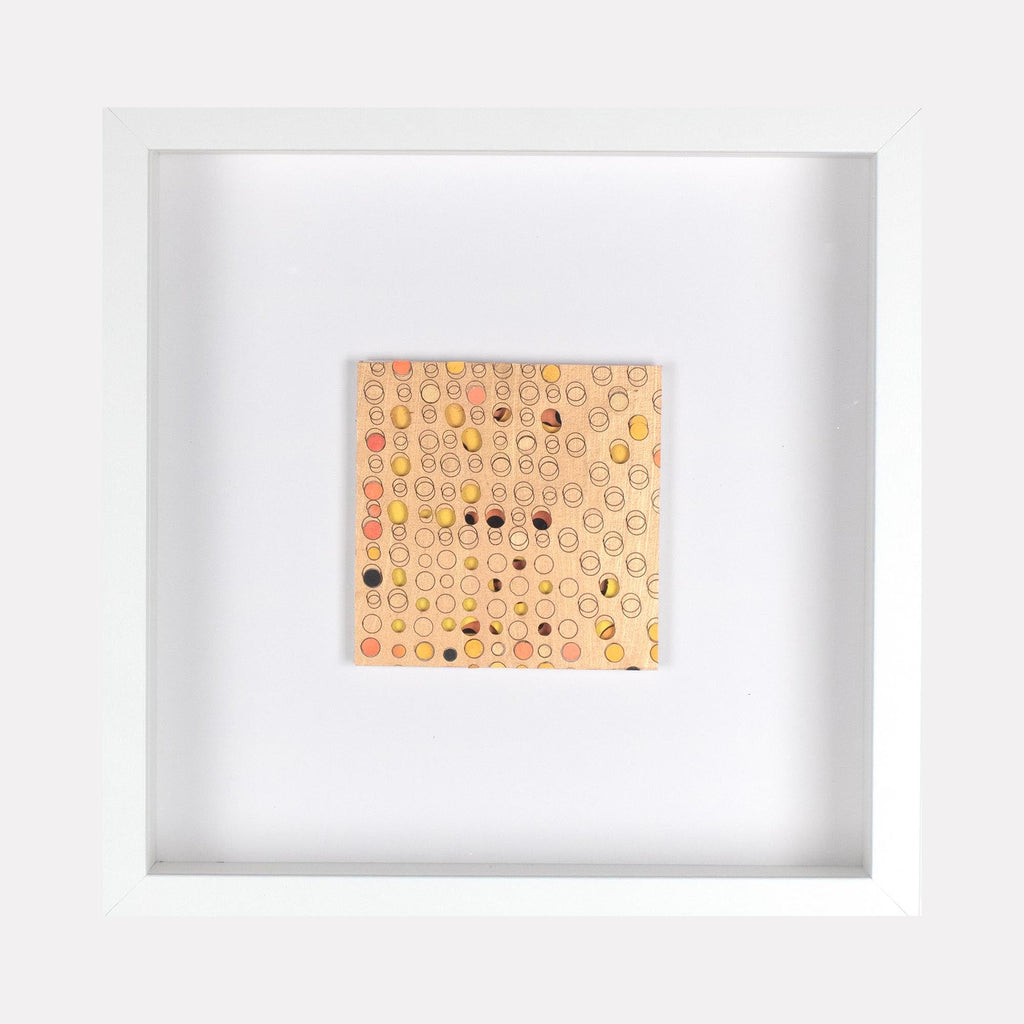 The artwork 'Ogilvy' by Margaret Griffith features a square composition of delicate circular patterns in soft peach and coral tones on cut paper. Small black dots are scattered throughout the geometric grid, creating a rhythmic abstract pattern. The piece is mounted in a clean white frame, measuring 9.75 x 9.75 inches, crafted with acrylic on cut paper.