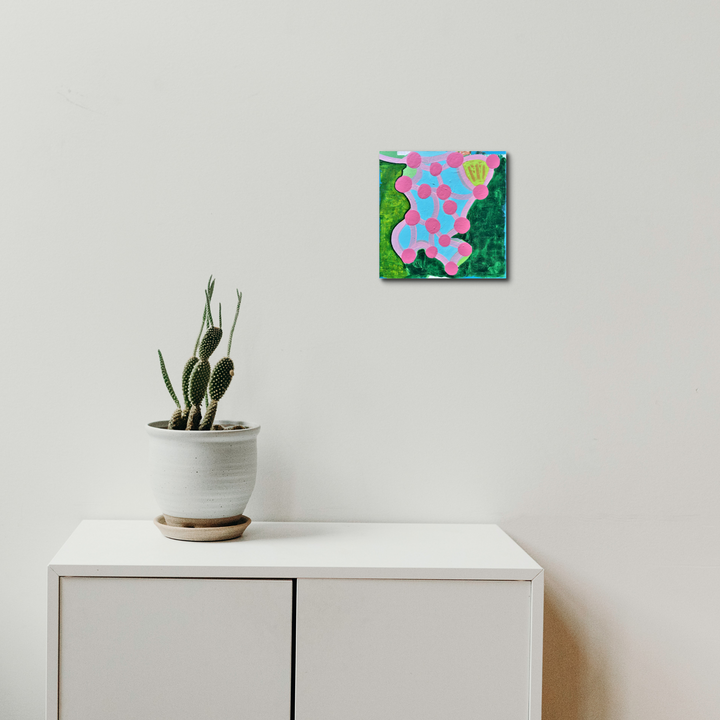 The artwork 'Composition No. 43' by Raul Ortiz features an abstract organic form in pink with blue polka dots against a vibrant emerald green background. Created on gridded paper with acrylic paint, the 10x10 inch piece mounted on cradled panel showcases a playful interplay of colors and biomorphic shapes.