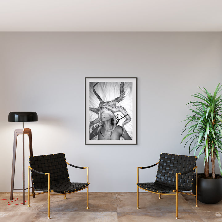 The artwork 'HOSHIKUZU' by Mari Sarai features a dramatic black and white photographic print showcasing an ethereal composition. The image displays expressive motion captured in high contrast, with flowing fabric elements creating dynamic vertical lines. Presented in a sleek black frame, printed on premium Hahnemuhle Paper as edition 20, measuring 40x32 inches. By Mari Sarai.