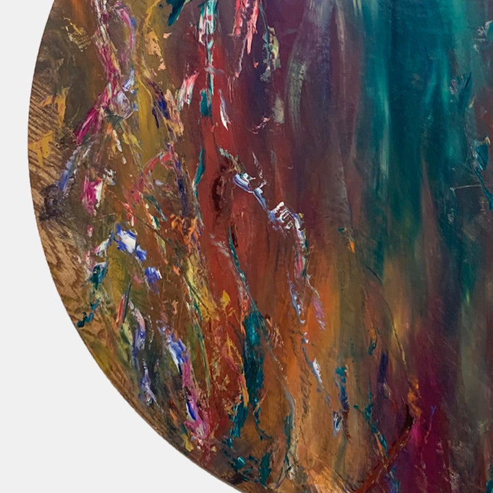 The artwork 'Impressions of Light 3' by Jadie Meprivert features dynamic brushstrokes in vibrant teal, burgundy, and amber hues, creating a textured abstract composition on circular wood panel. Expressive oil paint technique with layered colors and metallic accents creates depth and movement across the 48-inch diameter surface.