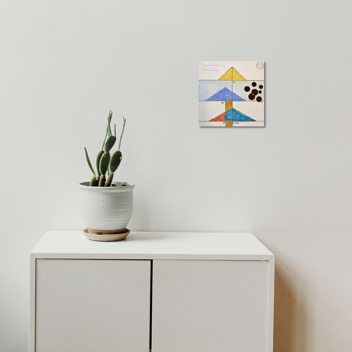 The artwork 'Signification Statistique' by Gauthier Denoyelle features geometric triangular shapes in yellow, blue, and orange, arranged in a mountain-like formation with black dots clustered in the upper right corner. Created with marker, crayon and pencil on 10x10 stretched canvas, displayed above a minimalist white cabinet with a potted cactus.